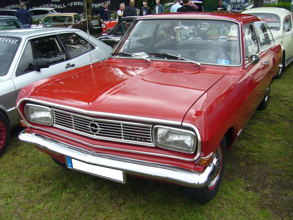 Opel Rekord B Limousine, gebaut von 1965 bis 1966. Der Rekord B war im Grunde ein facegelifteter Rekord A, in dem lediglich neu konstruierte Motoren verbaut wurden. Das Modell war als zwei- und viertürige Limousine, als Coupe, und dreitüriges Kombimodell namens CarAvan lieferbar. Der Kaufinteressent hatte drei Vierzylinderreihenmotoren zur Auswahl: 1.492 cm³ mit 60 PS, 1.698 cm³ mit 75 PS und 1.897 cm³ mit 90 PS. Der abgelichtete Rekord ist im Farbton granadarot lackiert. Oldtimertreffen an der Dreieckswiese in Duisburg am 01.08.2021.