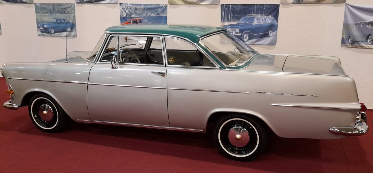 Opel Rekord P2 Coupe in der Farbkombination laplatasilber/ozeangrün, produziert von 1961 bis 1963. Während die P2 Limousine bereits im August 1960 vorgestellt wurde, folgte das Coupe genau ein Jahr später. Das Coupe war grundsätzlich mit dem stärksten Motor ausgestattet. Dieser Vierzylinderreihenmotor leistet 60 PS aus einem Hubraum von 1680 cm³. Ein solches Coupe schlug mit einem Kaufpreis von DM 7675,00 zu Buche. Aufgrund des kurzen Coupedaches und der großen Kofferraumklappe hat sich im Volksmund schnell der Spitzname  Der rasende Kofferraum  etabliert. Techno Classica Essen am 27.03.2022.