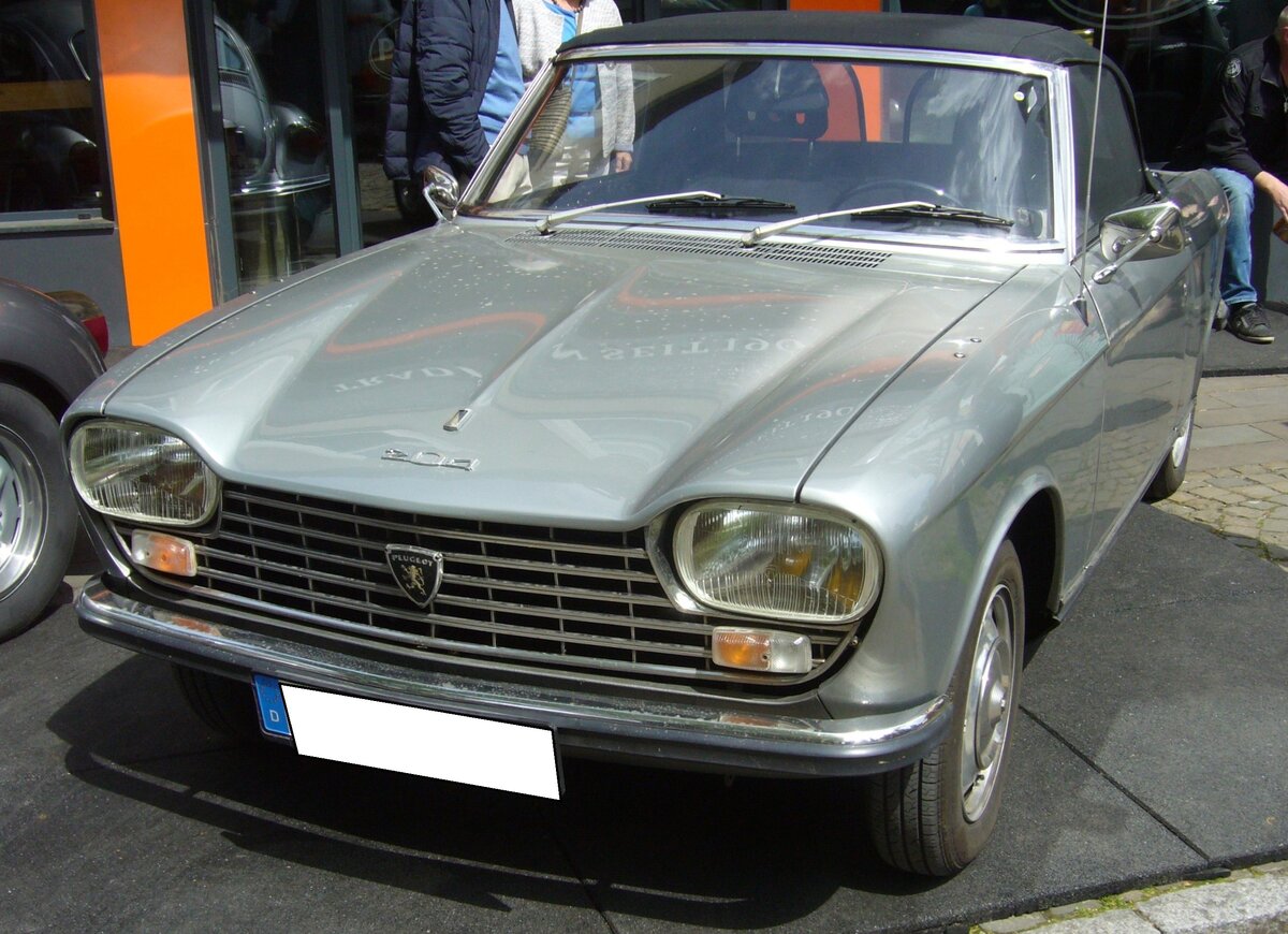 Peugeot 204 Cabriolet im Farbton gris clair. Der von Pininfarina gezeichnete Peugeot 204 kam im Frühsommer des Jahres 1965 auf den Markt. Anfang 1967 wurde die Modellpalette um weitere Karosserieversionen erweitert. Es handelte sich um das gezeigte Cabriolet, ein dreitüriges Coupe und ein fünftüriges Kombimodell mit der Typbezeichnung Break. Der quer verbaute Vierzylinderreihenmotor hat einen Hubraum von 1130 cm³ und leistet, je nach Vergaserbestückung, 53 PS oder 58 PS. 15. Oldtimertreffen des AMC Essen-Kettwig am 01.05.2023.