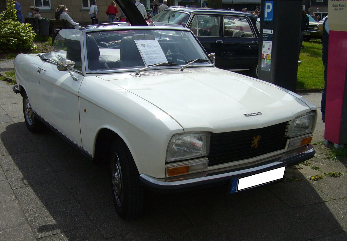 Peugeot 304S Cabriolet im Farbton blanc alaska, produziert in den Jahren von 1970 bis 1975 im Werk Sochaux. Das 304 Cabriolet basierte auf der bereits im Jahr 1969 erschienen 304´er Limousine. Während die Limousine und das Break genannte Kombimodell, auch mit einem Dieselmotor geordert werden konnten, waren das Coupe und das Cabriolet nur mit einem Benzinmotor lieferbar. Dieser Vierzylinderreihenmotor mit einem Hubraum von 1288 cm³ leistet bis zum Modelljahr 1973 65 PS. Ab dem Modelljahr 1974 erhöhte sich die Leistung auf 75 PS. Von den insgesamt 9.500 produzierten 304S Cabriolets wurden ca. 1.800 Stück in Deutschland verkauft. Der Kaufpreis betrug in der Grundausstattung DM 10.400,00 inclusive eines serienmäßigen Hardtopdaches. 15. Oldtimertreffen des AMC Essen-Kettwig am 01.05.2023.