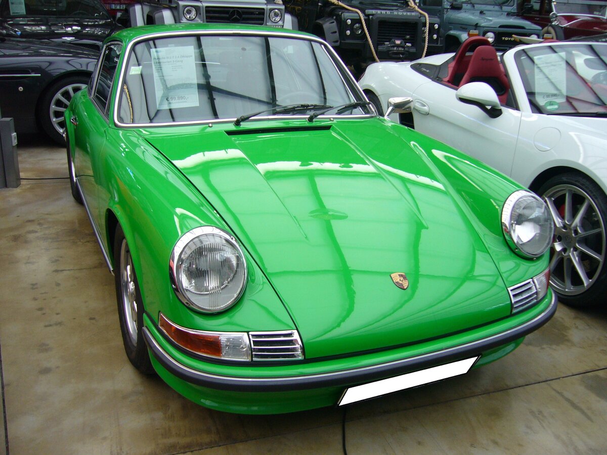 Porsche 911 2.4T aus dem Jahr 1972. Das gezeigte Coupe ist im Farbton vipergrün lackiert. Es handelt sich um ein so genanntes  Ölklappenmodell . Nur im Modelljahr 1972 war hinter der Beifahrertür eine kleine Klappe installiert, über die Motoröl eingefüllt werden konnte. Der im Heck verbaute, gebläsegekühlte, Sechszylinderboxermotor hat einen Hubraum von 2311 cm³ und leistet 140 PS. Classic Remise Düsseldorf am 23.11.2021.