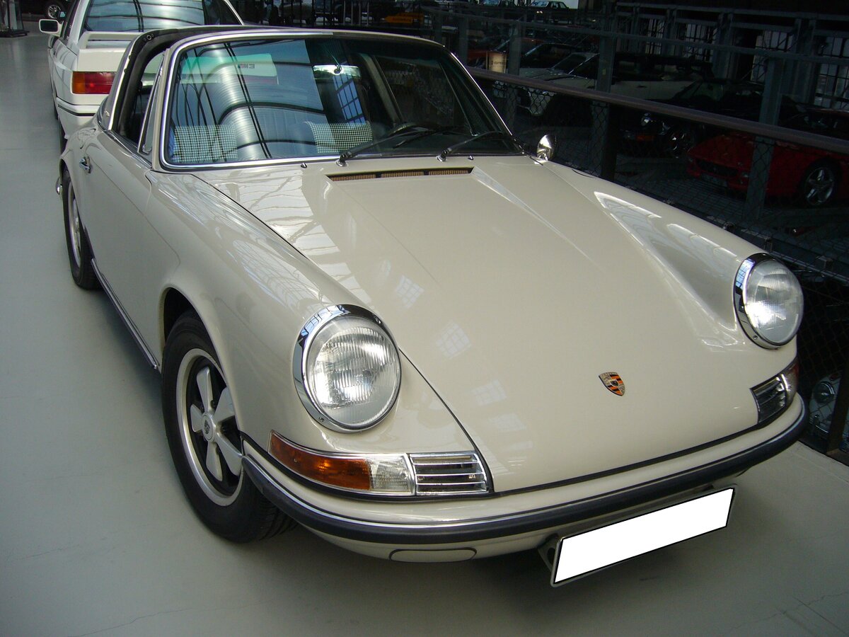 Porsche 911 2.4T Targa aus dem Jahr 1972. Der erste Porsche mit einem Targa-Dach wurde im September 1965 auf der Frankfurter IAA vorgestellt. Der gezeigte Targa im Farbton beigegrau 622 wurde 1972 in die USA ausgeliefert. Es handelt sich um ein so genanntes  Ölklappenmodell . Im Jahr 2010 kehrte er in sein Heimatland zurück und wurde umfangreich restauriert. Der im Heck verbaute, gebläsegekühlte Sechszylinderboxermotor hat einen Hubraum von 2311 cm³ und leistet 140 PS. Classic Remise Düsseldorf am 28.09.2021.