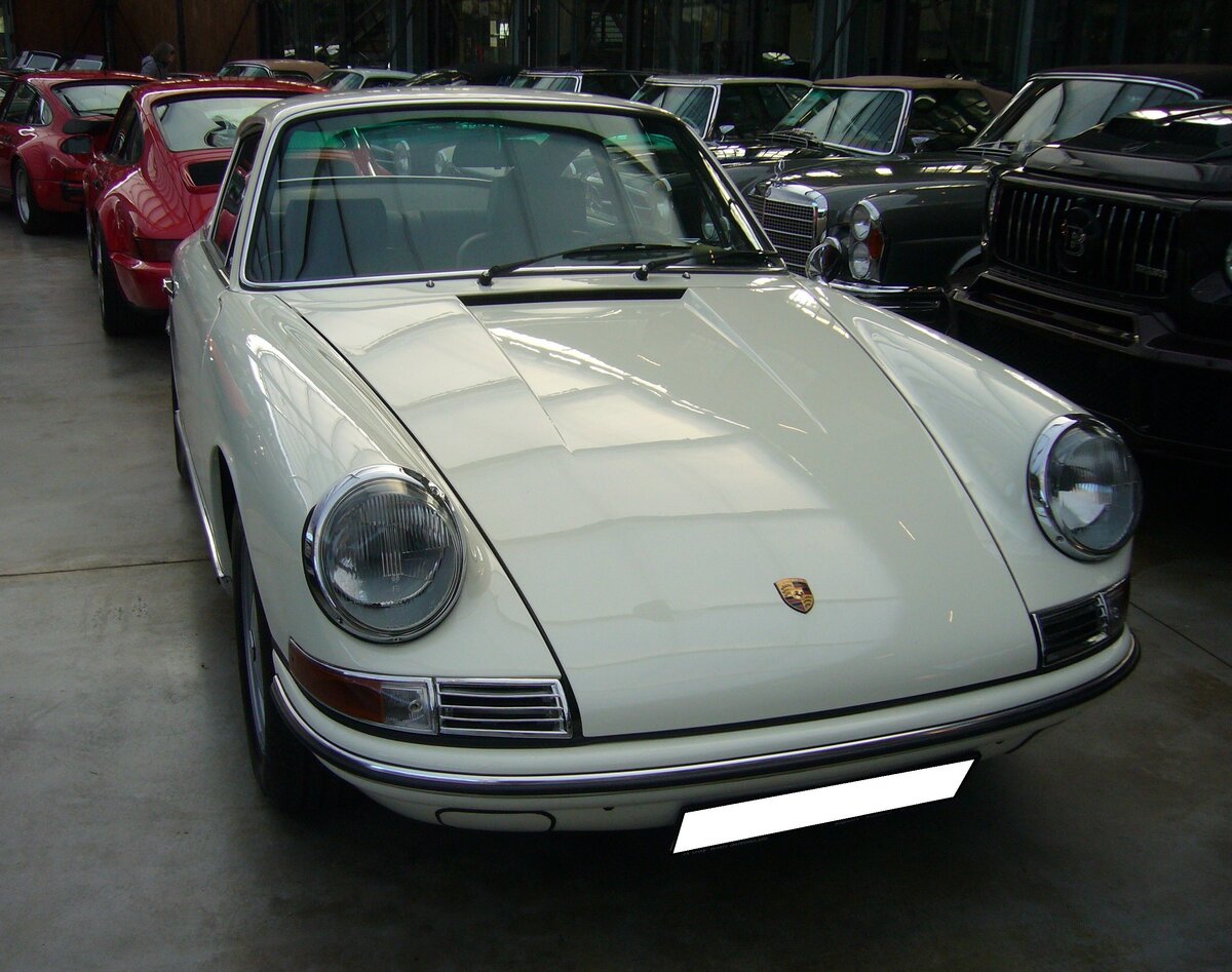 Porsche 911 aus dem Jahr 1966 im Farbton hellelfenbein. Dieser frühe Porsche 911, ein so genannter SWB ( s hort w heel b ase), wurde im November 1966 erstmalig im pfälzischen Kaiserslautern zugelassen. Der im Heck verbaute, gebläsegekühlte, Sechszylinderboxermotor hat einen Hubraum von 1991 cm³ und leistet 131 PS. Classic Remise Düsseldorf am 30.11.2023.