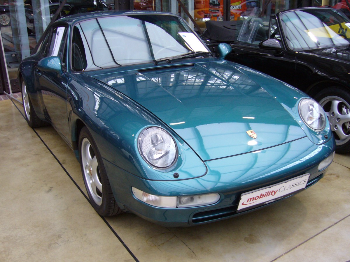 Porsche 911 der Baureihe 993. 1993 - 1998. Hier wurde ein 993 in der selten georderten Lackierung L25D -türkismetallic- abgelichtet. Der luftgekühlte 6-Zylinderboxermotor mit einem Hubraum von 3.6l leistet 286 PS. Classic Remise Düsseldorf am 30.01.2016.