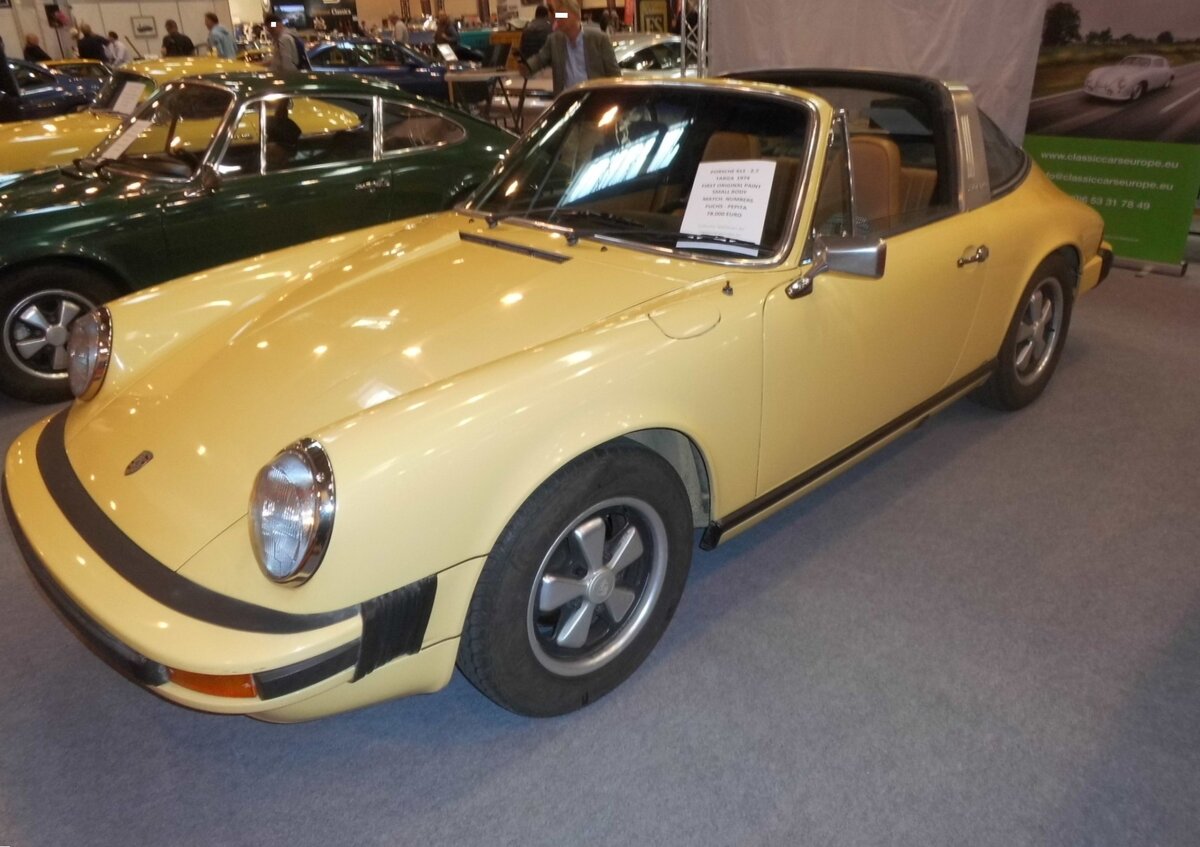 Porsche 911 Targa, der so genannten G-Serie, wie sie seit August 1973 in Zuffenhausen vom Band lief. Optisch waren diese Modell an den Faltenb�lgen der Sto�f�nger und dem roten  Porsche-Leuchtenband  zwischen den Heckleuchten zu erkennen. Der Sechszylinderboxermotor dieses sonnengelben 911´er Targa hat einen Hubraum von 2687 cm� und leistet 150 PS. Retro Classics Essen am 09.04.2026.