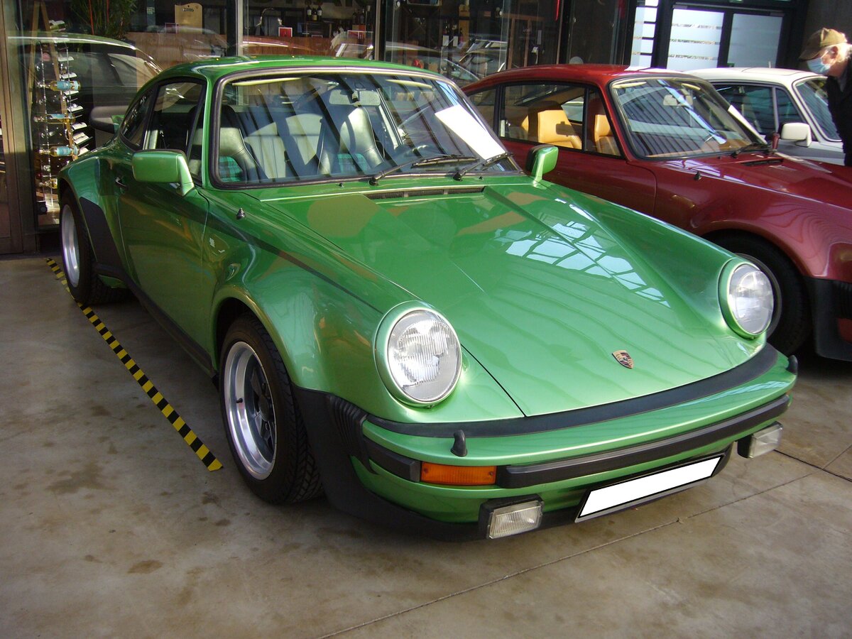 Porsche 911 (Typ 930) Ur-Turbo aus dem Jahr 1975. Dieser, im Farbton Y9 Viper-grün lackierte, 930´er wurde im September 1975 in Kaiserslautern zugelassen. Er gehörte zu einer Serie von 400 Homologationsmodellen für die Rennserie 4. Der im Heck verbaute Sechszylinderboxermotor mit Turboaufladung hat einen Hubraum von 2956 cm³ und leistet 260 PS. Classic Remise Düsseldorf am 13.02.2022.