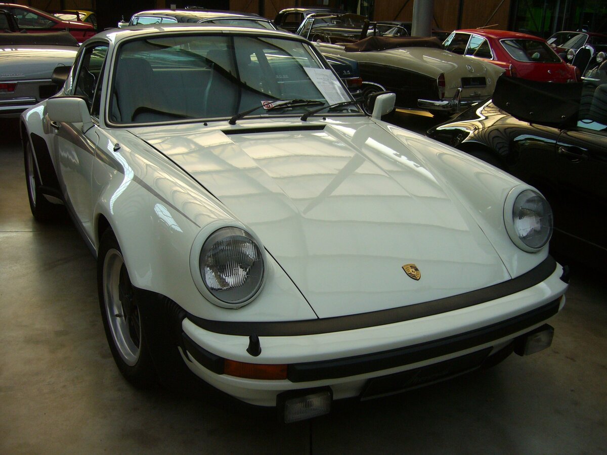 Porsche 911 (Typ 930), der Ur-Turbo aus dem Jahr 1977 im Farbton grandprix weiß. Der Wagen gehörte zu einer Serie von 400 Homologationsmodellen für die Rennserie 4. Der im Heck verbaute Sechszylinderboxermotor mit Turboaufladung hat einen Hubraum von 2993 cm³ und leistet 260 PS. Classic Remise Düsseldorf am 20.07.2022.