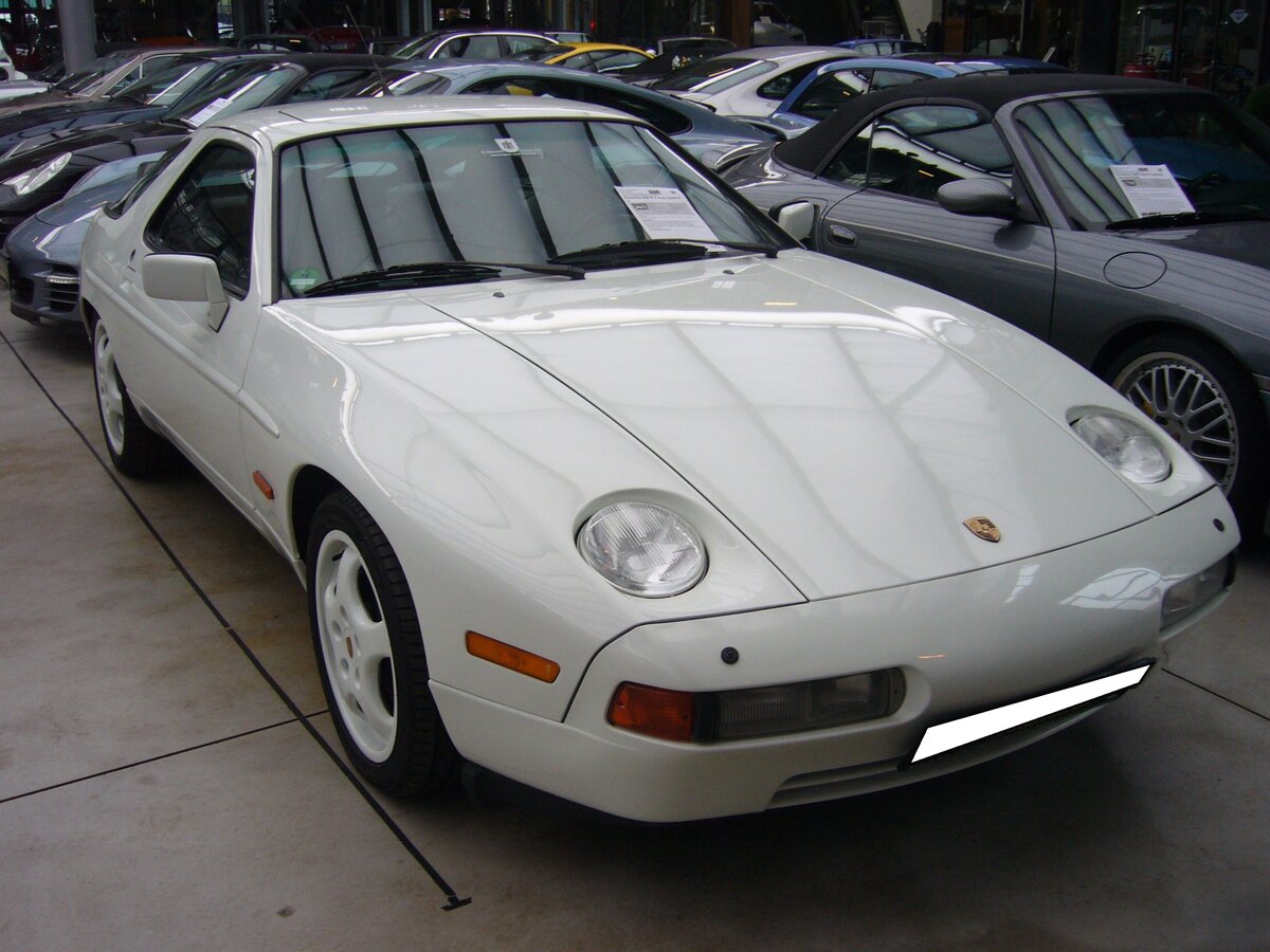 Porsche 928 S4 im Farbton Grandprix weiß aus dem Jahr 1992. Der 928 kam im Jahr 1977 auf den Markt und wurde in etlichen Versionen bis 1995 gebaut. Ein Novum für die Zuffenhausener war der Frontmotor. Hier konnte ich einen 928 S4 ablichten. Das Modell war mit einem Fünfgang-Schalt- und Automaticgetriebe lieferbar. Ab dem Modelljahr 1991 waren sogar schon Airbags serienmäßig. Motorisiert ist das Auto mit einem V8-Motor mit einem Hubraum von 4957 cm³ und einer Leistung von 320 PS. Mit einem cw-Wert von 034 erreicht der Wagen eine Höchstgeschwindigkeit von 270 km/h. Ist der 928´er mit einem Automaticgetriebe ausgerüstet, vermindert sich diese um 5 km/h. Classic Remise Düsseldorf am 26.02.2024.