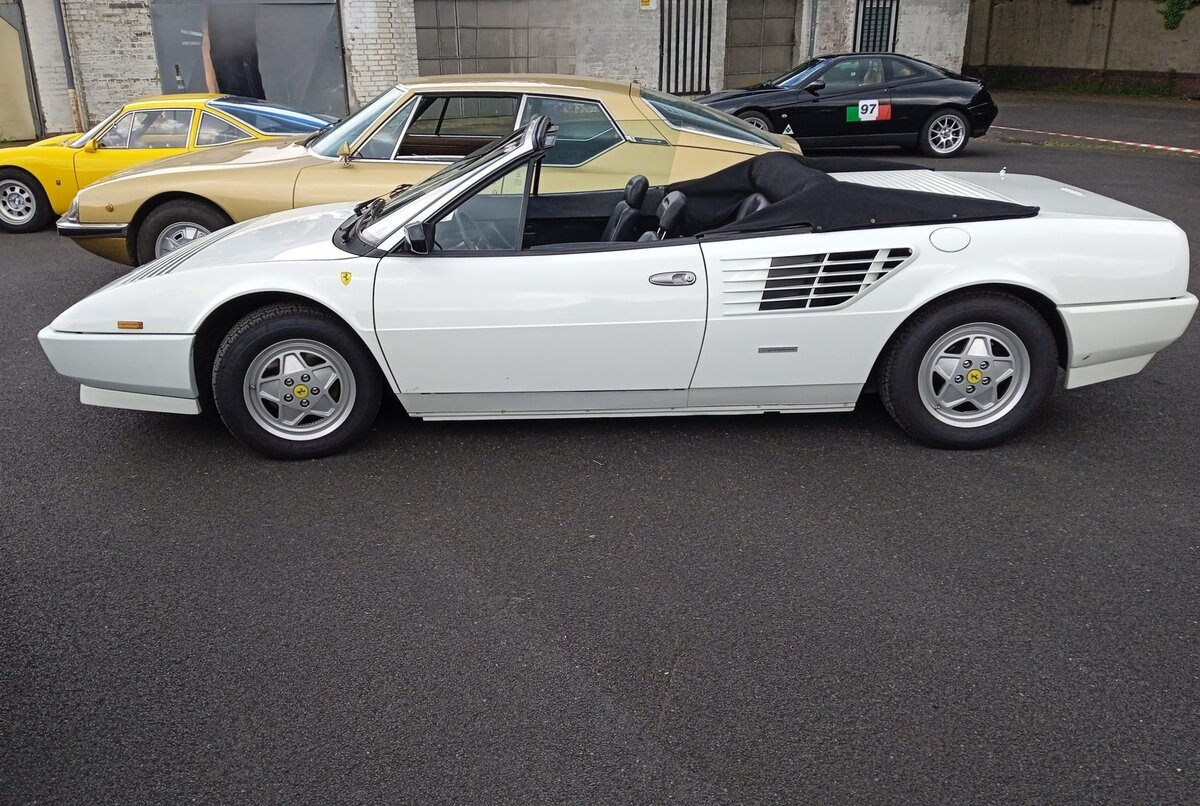 Profilansicht eines Ferrari Mondial 3.2 Cabriolet im Farbton bianco polo aus dem Jahr 1989. Dieses Cabriolet wurde somit im letzten Modelljahr der ersten Mondial-Generation, produziert. Der Mondial war auch in einer geschlossenen Coupe-Version lieferbar. Der V8-Motor hat im Mondial 3.2 einen Hubraum von 3185 cm³ und leistet 270 PS. Die Höchstgeschwindigkeit gab der Hersteller mit 250 km/h an.  Forza Italia  = Treffen für italienische Fahrzeuge an Mo´s Bikertreff am 30.05.2024 in Krefeld.