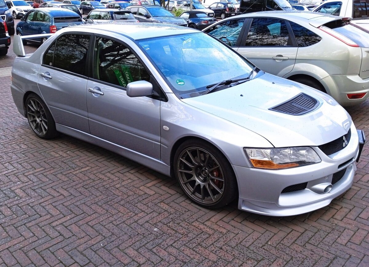 Profilansicht eines Mitsubishi Lancer Evolution IX. Im Jahr 2005 kam die mittlerweile neunte Generation des Mitsubishi Lancer Evolution auf den Markt. Der monströse Heckflügel, die aggressive Front mit den riesigen Lufteinlässen und der funktionale Innenraum wurden vom Vorgängermodell übernommen. Der Vierzylinderreihenmotor mit einem Hubraum von 1997 cm³ und Turbo-Turboaufladung, sowie einer variablen Ventilsteuerung leistet, je nach Ausführung zwischen 280 PS und 345 PS. Die Leistung wird mittels eines permanenten Allradantriebs auf die Straße gebracht. Zum Modelljahr 2008 wurde das Modell durch den Lancer Evolution X abgelöst. Oldtimertreffen an der Motor World Herten im April 2024.