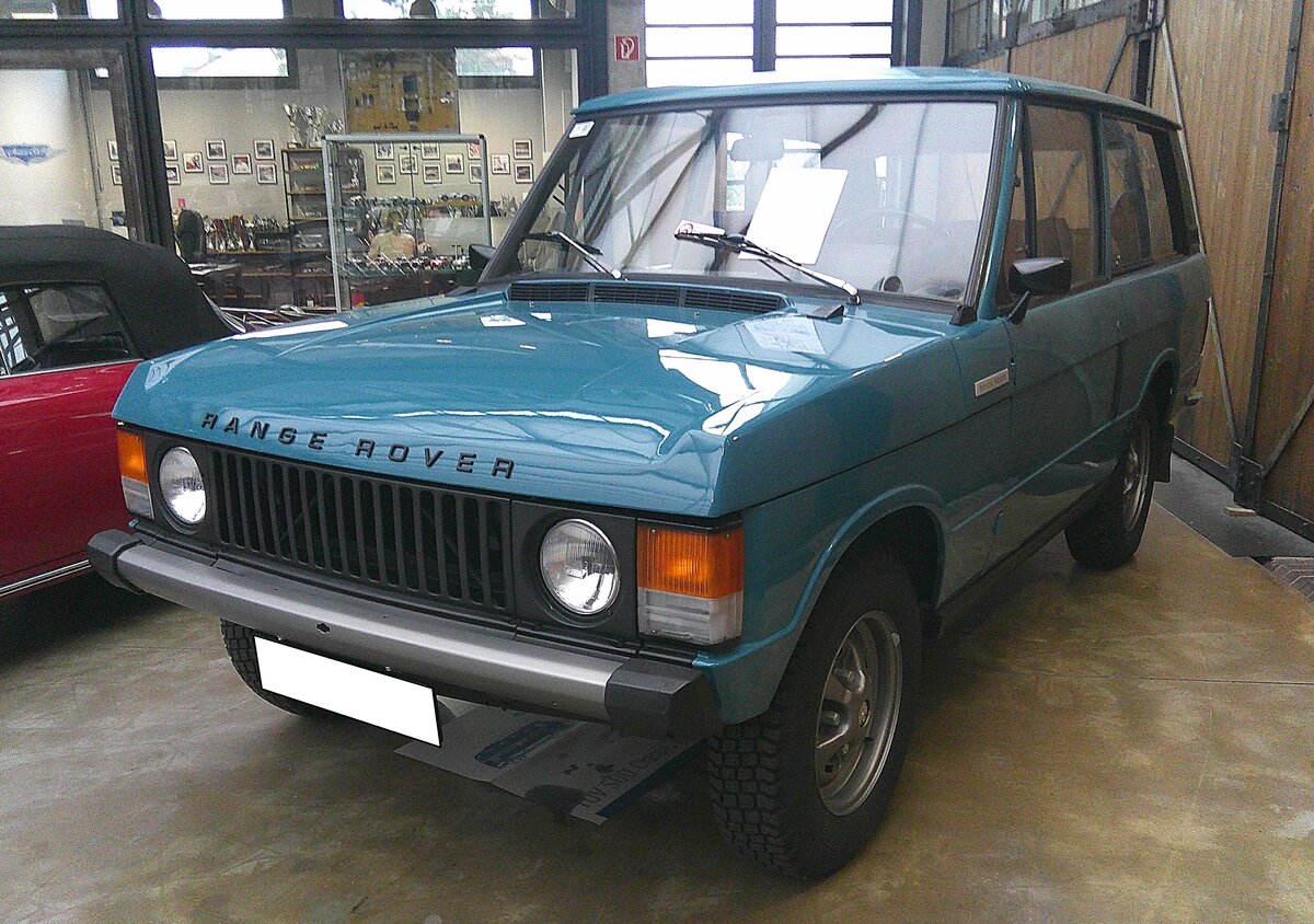 Range Rover MK1 im Farbton tuscan blue aus dem Jahr 1977. Der Range Rover wurde am 17. Juni 1970 offiziell vorgestellt und in dieser Urform bis 1996 hergestellt. Dabei wurde das Modell jedoch technisch ständig weiterentwickelt. Sein permanenter Allradantrieb, Schraubenfederung und nicht zuletzt der V8-Motor haben damals den Geländewagenmarkt revolutioniert. Der Range Rover galt bereits damals als Vorbild für eine Reihe anderer luxuriöser Geländewagen. Trotz seiner komfortablen, auf Wunsch und gegen Aufpreis sogar luxuriösen Innenausstattung, sowie  seines straßentauglichen Erscheinungsbildes ist der Range Rover ein tauglicher Geländewagen. Der lange Federweg der Achsen und die relativ hohe Bodenfreiheit sorgen auch unter schwierigen Bedingungen für Bodenhaftung. Der V8-Motor hat einen Hubraum von 3470 cm³ und leistet 132 PS. Classic Remise Düsseldorf am 15.01.2026.