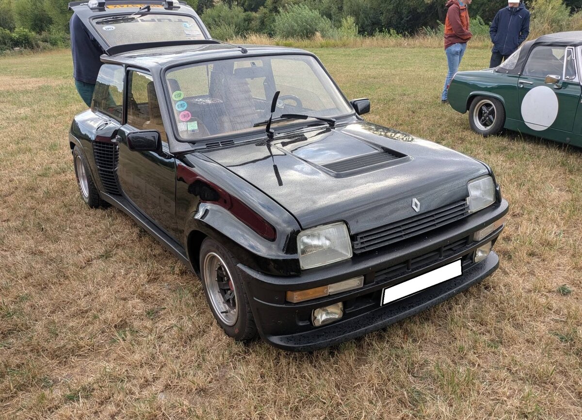 Renault R5 Turbo der zweiten Generation, so wie er von 1982 bis 1986 zu einem recht hohen Preis verkauft wurde. Der  R5 Turbo  sah optisch dem normalen R5 �hnlich, war aber eine komplette Neukonstruktion mit Mittelmotor und Heckantrieb. Um Platz f�r den Mittelmotor zu schaffen, verzichtete man bei diesem Auto auf die hintere Sitzbank. Er war somit ein reiner Zweisitzer. Der Kaufpreis lag 1983 in etwa bei dem einer Mercedes Benz S-Klasse der Baureihe W126. Der Vierzylinderreihenmotor mit einem Hubraum von 1397 cm� leistet, mittels eines Turboladers, 160 PS. Chainbridge/Wales im Juli 2025. Treffen des Chainbridge classic car club auf der Wiese vor einem Pub in Chainbridge/Wales im Juli 2025.