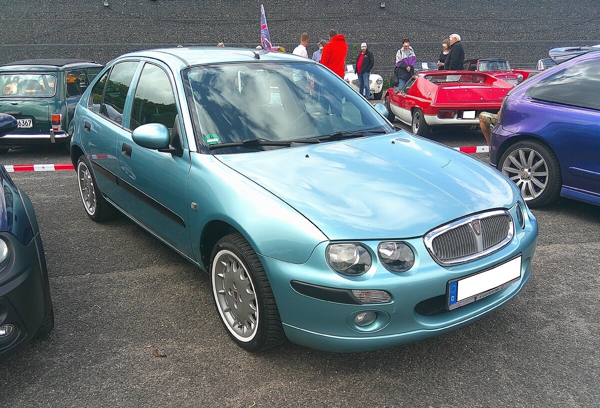 Rover 25 im Farbton teal blue aus dem Jahr 2004. Der Kleinwagen der MG-Rover-Group kam im Sp�tsommer des Jahres 1999 auf den Markt. Im April 2005 endete die Produktion abrupt durch die Insolvenz der MG Rover Group. Das Modell war als drei- und f�nft�rige Flie�hecklimousine lieferbar. Der  25  war mit vier verschiedenen Vierzylinder-Benzinmotoren und einem 2.0 Liter Dieselmotor lieferbar. 10. BCMM ( B ritish C ar M otorcycle M eeting) am 19.07.2026 an Mo´s Bikertreff in Krefeld.