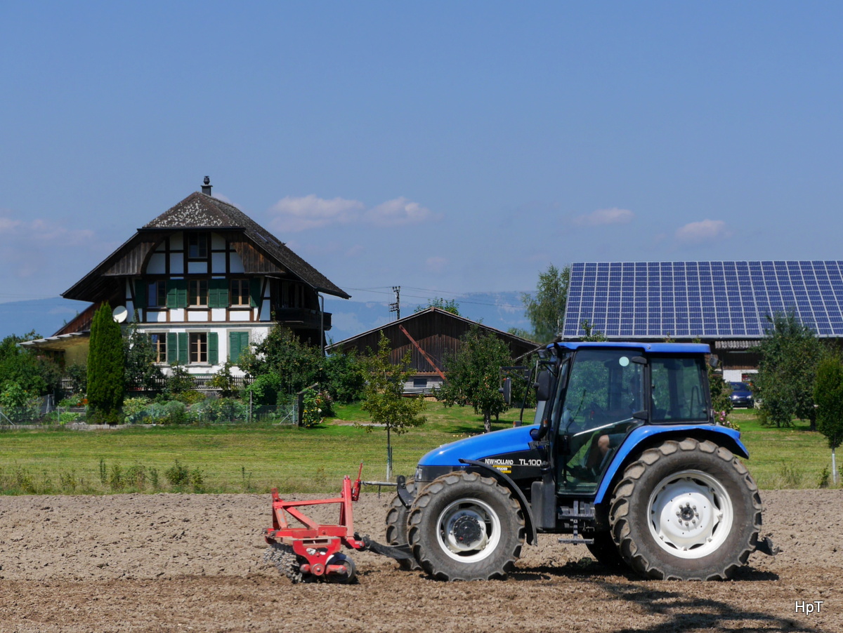 Traktor New Holland TL 100 auf einem Feld bei Lyssach am 22.08.2015