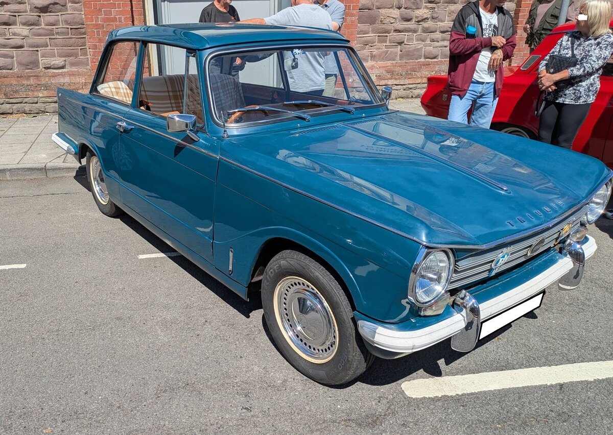 Triumph Herald 13/60 Saloon im Farbton valencia blue aus dem Modelljahr 1968. Dieses Modell wurde von 1967 bis 1971 angeboten und war als Saloon (Limousine, Convertible (Cabriolet) und als Estate (Kombi) lieferbar. Die Karosserie wurde vom ber�hmten italienischen Designer Giovanni Michelotti (*1921 +1980) gezeichnet. Wie bei einigen anderen Triumph-Modellen auch, l�sst sich die gesamte Frontpartie nach vorne klappen, was die Wartung des Motors besonders einfach macht. Der Vierzylinderreihenmotor hat einen Hubraum von 1296 cm� und leistet zwischen 61 PS und 63 PS. Die H�chstgeschwindigkeit soll rund 130 km/h betragen. Brynmawr Classic Car Show/South Wales am 26.07.2026.