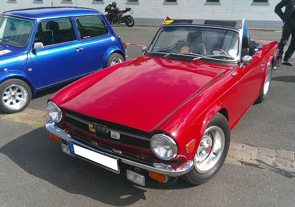 Triumph TR6 im Farbton carmine red red, produziert in den Jahren von 1970 bis 1976. Im Jahr 1970 erschien der letzte Abk�mmling der klassischen Triumph TR-Baureihe in Form des TR6. Die Karosserie hatte der legend�re Italiener Giovanni Michelotti (*1921 +1980) gezeichnet. Der Sechszylinderreihenmotor des TR6 stammt vom Triumph 2000 und wurde auf 2498 cm� Hubraum aufgebohrt. Dieser Motor leistet 150 PS und beschleunigt den TR6 auf eine H�chstgeschwindigkeit von 190 km/h. Der gezeigte TR6 wurde 1972 erstmalig zum Stra�enverkehr zugelassen. 10. BCMM ( B ritish C ar M otorcycle M eeting) am 19.07.2026 an Mo´s Bikertreff in Krefeld.