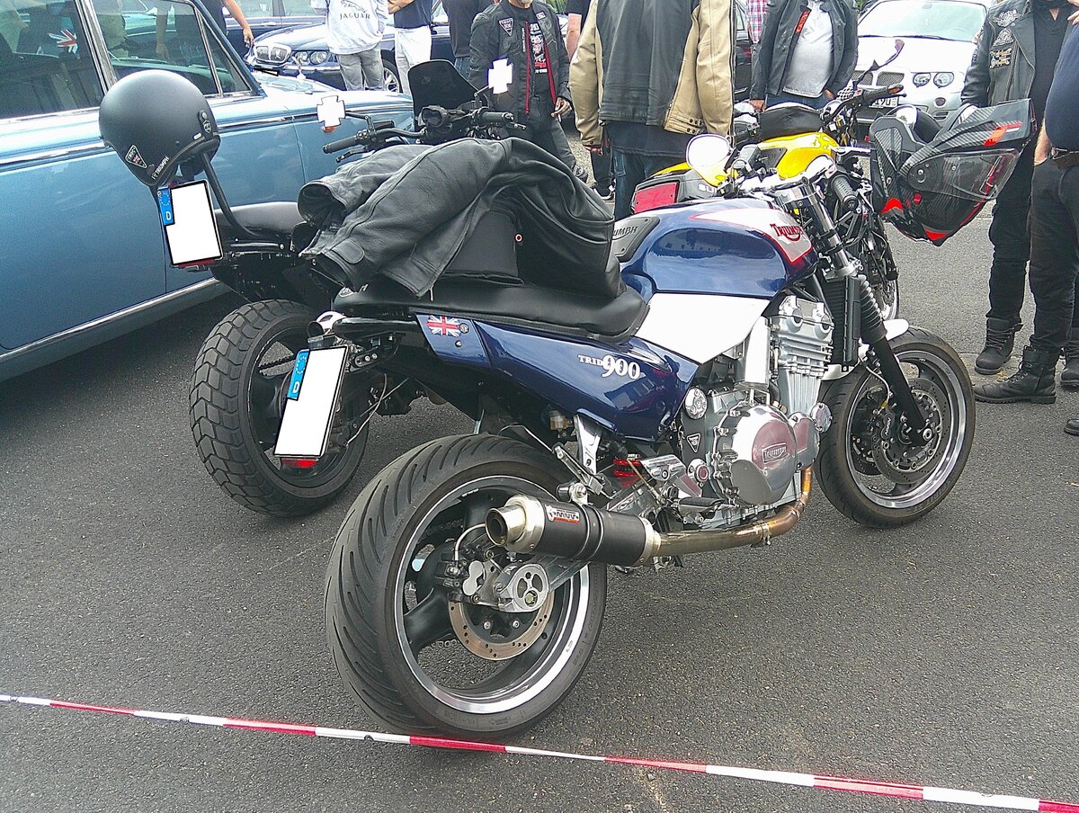 Triumph Trident 900. Die  Trident 900  war ein Naked-Bike der so genannten Baureihe T300. Montiert wurde dieses Modell und das kleinere Schwestermodell  Trident 750  ab 1991 im Werk Hinckley/Leicestershire. Beide Modelle blieben bis 1998 im Verkaufsprogramm der britischen Motorradschmiede. Der Fl�ssigkeitsgek�hlte Dreizylinderreihenmotor hat einen Hubraum von 885 cm� und leistet serienm��ig 98 PS. Die Spitzengeschwindigkeit wurde mit rund 218 km/h angegeben. Ein zeitgen�ssischer Tester schrieb damals: Die Trident 900 bietet eine entspannte Sitzposition, die sich hervorragend f�r Touren eignet. Aufgrund des soliden Motors sch�tzen Liebhaber sie als langlebigen Klassiker, auch wenn das hohe Leergewicht und die Bremsleistung der fr�hen Baujahre etwas Eingew�hnung erfordern. 10. BCMM ( B ritish C ar M otorcycle M eeting) am 19.07.2026 an Mo´s Bikertreff in Krefeld.