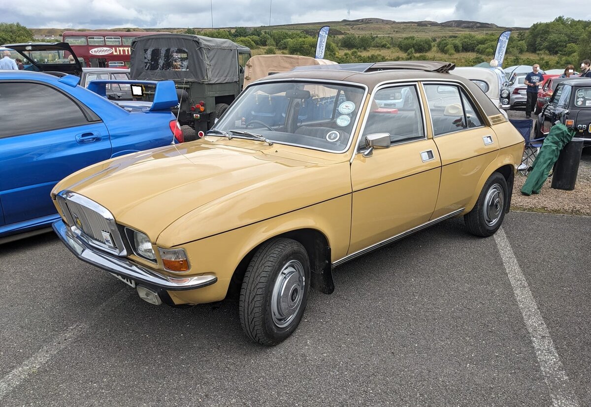 Vanden Plas 1500 MK2. Das Modell wurde im September 1974 als Nachfolger des Princess 1300 vorgestellt. Das Auto basierte auf dem Austin Allegro 1300. Wie bei Vanden Plas üblich, wurde etliche luxuriöse Features verbaut. Diese waren unter anderem: Eine besonders gestaltete Armaturentafel, die genau, wie ein Teil der Türverkleidungen mit hochglanzpoliertem Walnussholz verziert war, die Sitze waren mit Leder bezogen, der Boden war mit extra schalldämmenden Teppichen ausgelegt und das Dach des Innenraumes war mit Nylonstoff verkleidet. Außen erhielt das Fahrzeug einen verkleinerten Vanden Plas-Kühlergrill, besonders glänzende Zierleisten um jedes Fenster, zwei verchromte Außenspiegel, Edelstahl-Einstiegsleisten und Stoßfänger mit Gummiauflage. Insgesamt wurden vom Modell MK2 bis Oktober 1979 genau 7918 Autos verkauft. Der Vierzylinderreihenmotor hat einen Hubraum von 1483 cm³ und leistet 68 PS. Zu erwähnen bleibt noch, das dieses Modell damals schon serienmäßig mit einem Fünfganggetriebe ausgestattet war. Oldtimer meeting in Blaenavon/South Wales am 13.07.2024.