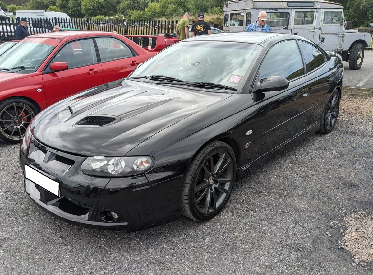 Vauxhall Monaro VXR. Ursprünglich kam der  Monaro  aus Australien. Dort lief er als Holden Monaro bzw. Holden Commodore vom Band und fand später seinen Weg ins Vereinigte Königreich. Obwohl Vauxhall und Holden GM-Töchter sind, wurde der  Monaro  nie über Opel in Kontinentaleuropa verkauft. Das Modell war mit etlichen Motorisierungen, aber auch als Pickup namens  Maloo  zu bekommen. Das gezeigte Coupe aus dem Jahr 2005 hat einen V8-Motor aus dem Chevrolet Corvette. Dieser hat einen Hubraum von 5667 cm³ und leistet rund 405 PS. Oldtimer meeting in Blaenavon/South Wales am 13.07.2024.