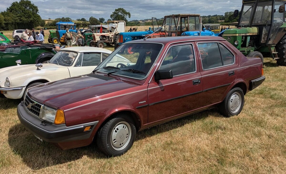 Volvo 340GLE. Die Volvo 300`er-Reihe wurde von 1976 bis 1991 in den ehemaligen DAF-Werken in Eindhoven/Niederlande gebaut. Bekannt f�r die Transaxle-Bauweise gab es das Kompaktklasse-Modell mit der legend�ren, schon von DAF entwickelten, stufenlosen Variomatik, aber auch mit einem klassischem Schaltgetriebe. Die kantigen Hecktriebler pr�gten das Stra�enbild als Drei- (343), F�nft�rer (345) sowie Stufenhecklimousine (340). Sie wurden von Renault-Motoren angetrieben. Der gezeigte 340GLE ist mit dem st�rksten, damals lieferbaren Motor ausgestattet. Der Vierzylinderreihenmotor, bekannt als Renault F-Motor, hat einen Hubraum von 1721 cm� und leistet, je nach Auslieferungsland, 82 PS oder 83 PS. Classic car meeting in Pontypool/South Wales am 17.05.2025.