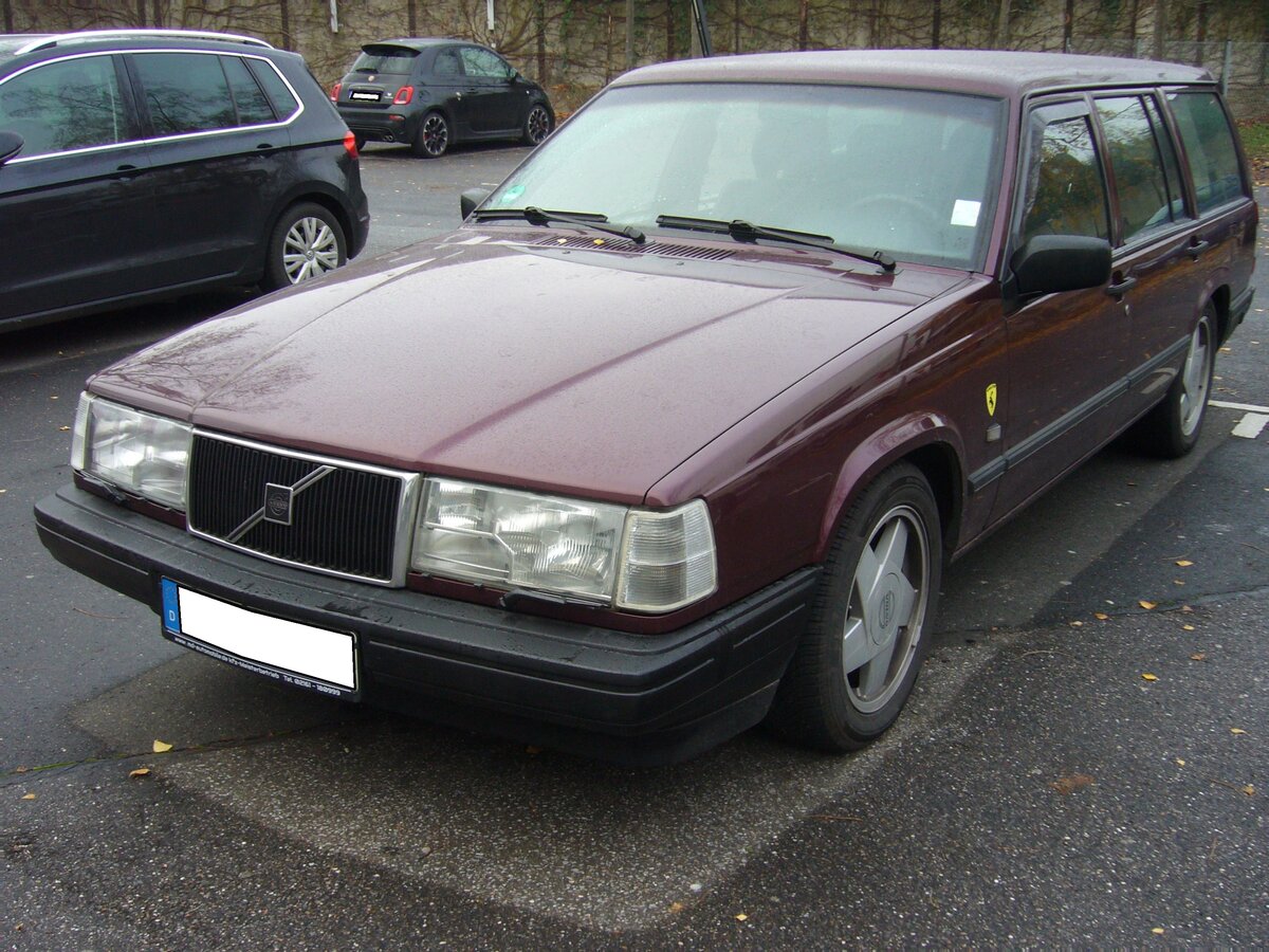 Volvo 940 Kombi. Die so genannte Volvo 900´er Serie kam 1990 auf den Markt und wurde bis 1998 mit einigen optischen und technischen Retuschen produziert. Die Baureihe war als viertürige Limousine oder fünftüriges Kombimodell lieferbar. Die 940´er Modelle waren mit einem Vierzylinderreihenmotor ausgerüstet, während die 960´er Modelle Sechszylinderreihenmotoren haben. Hier konnte ich ein Modell der Baujahre von 1994 bis 1996 ablichten. Es waren 2.0l und 2.3l Benzinmotoren mit einem Leistungsspektrum von 112 PS bis 165 PS lieferbar. Besucherparkplatz der Düsseldorfer Classic Remise am 23.11.2021.