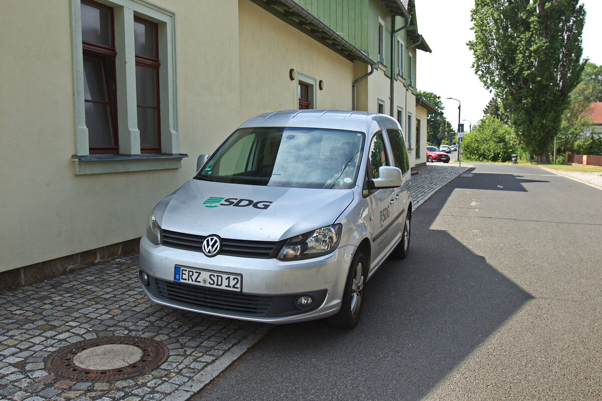 VW Caddy der SDG Sächsische Dampfeisenbahngesellschaft mbH aufgenommen am Bahnhof Moritzburg am 08. Juli 2023. Das Fahrzeug ist an 3 Seiten mit dem Logo der SDG beschriftet/foliert.
