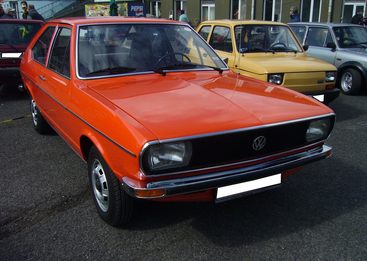 VW Passat Typ 32 als zweitürige Limousine aus dem Jahr 1974 im damals beliebten Farbton mandarin. Im Frühjahr 1973 wurde der neue VW Passat vorgestellt. Er löste den in die Jahre gekommenen VW Typ 3 ab. Technisch abgeleitet wurde der Passat vom damaligen Audi 80. Für das äußere Erscheinungsbild zeigte sich Giugiaro von Ital-Design verantwortlich. Der hier gezeigte Passat in der L-Ausstattung war das Basismodell in der Typenpalette. 1974 stand ein solcher Passat mit einem Kaufpreis von mindestens DM 9600,00 in der Preisliste. Der Passat L hat einen quer eingebauten Vierzylinderreihenmotor mit einem Hubraum von 1297 cm³ und einer Leistung von 55 PS. Die Höchstgeschwindigkeit gab VW mit 150 km/h an. Oldtimertreffen an   Mo´s Bikertreff in Krefeld am 10.04.2022.