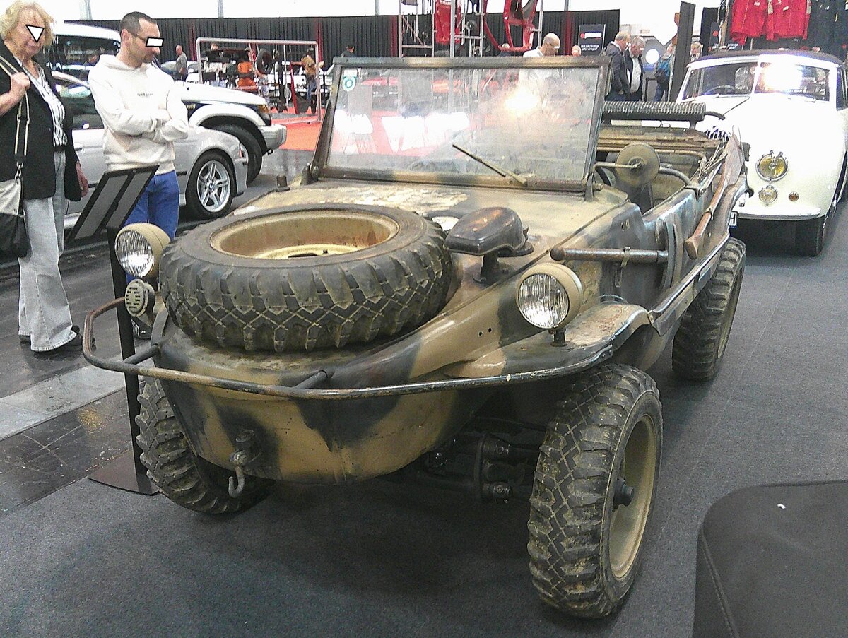 VW Typ 166  Schwimmwagen  aus dem Jahr 1944. Der Schwimmwagen basierte technisch auf dem Volkswagen Kübelwagen, der wiederum vom zivilen KdF-Wagen abgeleitet war, der später als Volkswagen Käfer bekannt wurde. Gebaut wurde es vom Volkswagenwerk in der Stadt des KdF-Wagens/heute Wolfsburg. Angetrieben wird der Typ 166 vom luftgekühlten Vierzylinderboxermotor aus dem KdF-Wagen, allerdings mit einem größerem Hubraum von 1131 cm³ und einer Leistung von 25 PS. Der Motor treibt wahlweise zwei oder vier Räder an. Am Heck des Wagens befindet sich ein kippbarer Dreiblattpropeller, der im abgesenkten Zustand über eine kurze Kette von einer Zapfwelle am Motor angetrieben wird. Insgesamt wurden mehr als fünfzehntausend Schwimmwagen gebaut. Der Schwimmwagen wurde häufig zur Aufklärung eingesetzt und hatte an der Front eine durchschnittliche Lebensdauer von sechs Wochen. Die Produktion wurde 1944 eingestellt. Somit stammt der gezeigte  Schwimmwagen  aus dem letzten Produktionsjahr. Retro Classics in Essen am 09.04.2026.