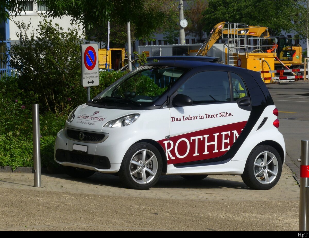 Weisser Smart mit Werbung abgestellt auf einem Parkplatz in der Stadt Basel am 10.05.2022