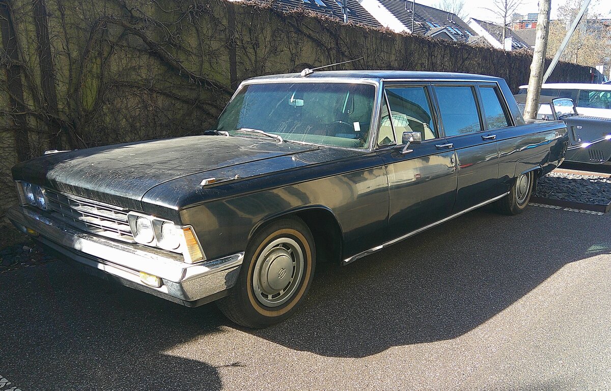 ZIL 114. Die repräsentative Limousine wurde im November des Jahres 1967 vorgestellt und bis ins Jahr 1986 in kleinen Serien gebaut. Die 6,30 Meter lange Limousine hatte erstaunlich viel Ähnlichkeit mit zeitgenössischen Chrysler und Imperial Limousinen aus US-Produktion. Der V8-Motor aus Leichtmetall hat einen Hubraum von 6559 cm³ und leistet genau 300 PS. Trotz eines Leergewichtes von 3085 Kilogramm soll diese Limousine eine Höchstgeschwindigkeit von 190 km/h erreicht haben. Besucherparkplatz der Düsseldorfer Classic Remise am 02.03.2026.