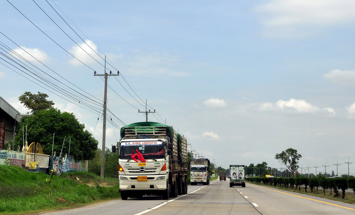 Zwei jeweils 3-achsige Hino QDR 500 LKW mit jeweils 3-achsigem Anhänger fahren auf dem Standstreifen in gegensätzlicher Fahrtrichtung auf dem AH (Asian Highway) 12 zwischen Khoen Kaen und Saraburi (Thailand) am 08.07.14, in Thailand kein Grund zur Aufregung.