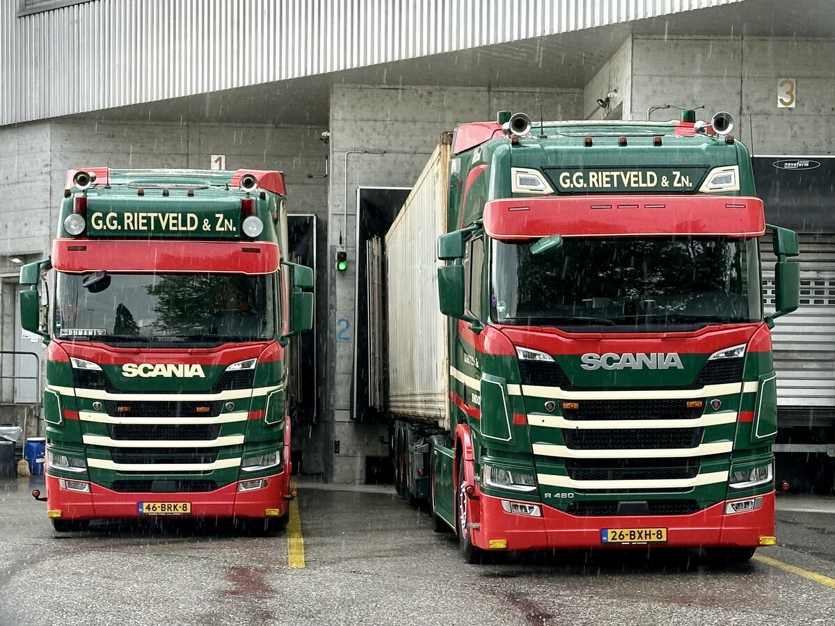 Zwei Scania Sattelz�ge von G.G. Rietveld am 15.7.26 in Bern Br�nnen, durch ein Zaun fotografiert.
