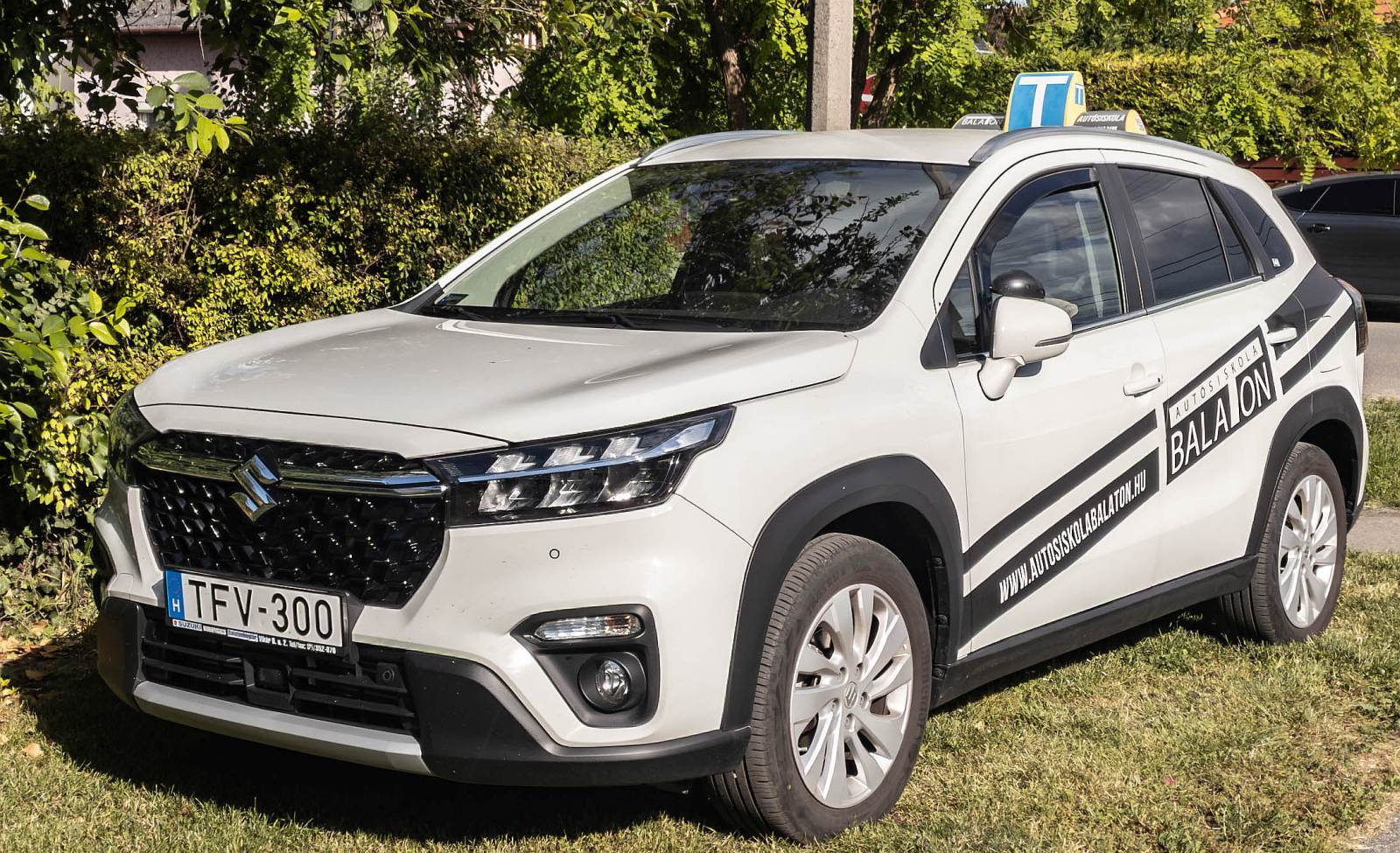 Dieser 2022-er Suzuki S-Cross gehört zu einer Fahrschule in Siófok, Ungarn. Die Aufnahme stammt von Mai, 2025
