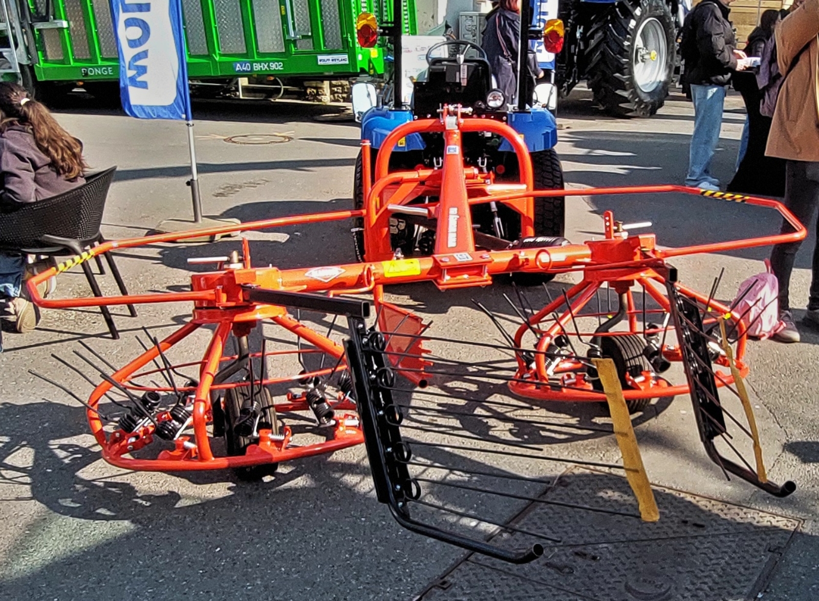 Heuwender an einem Schmalspurtraktor, gesehen beim Tag auf dem Bauernhof in der Stadt Luxemburg. 03.2026