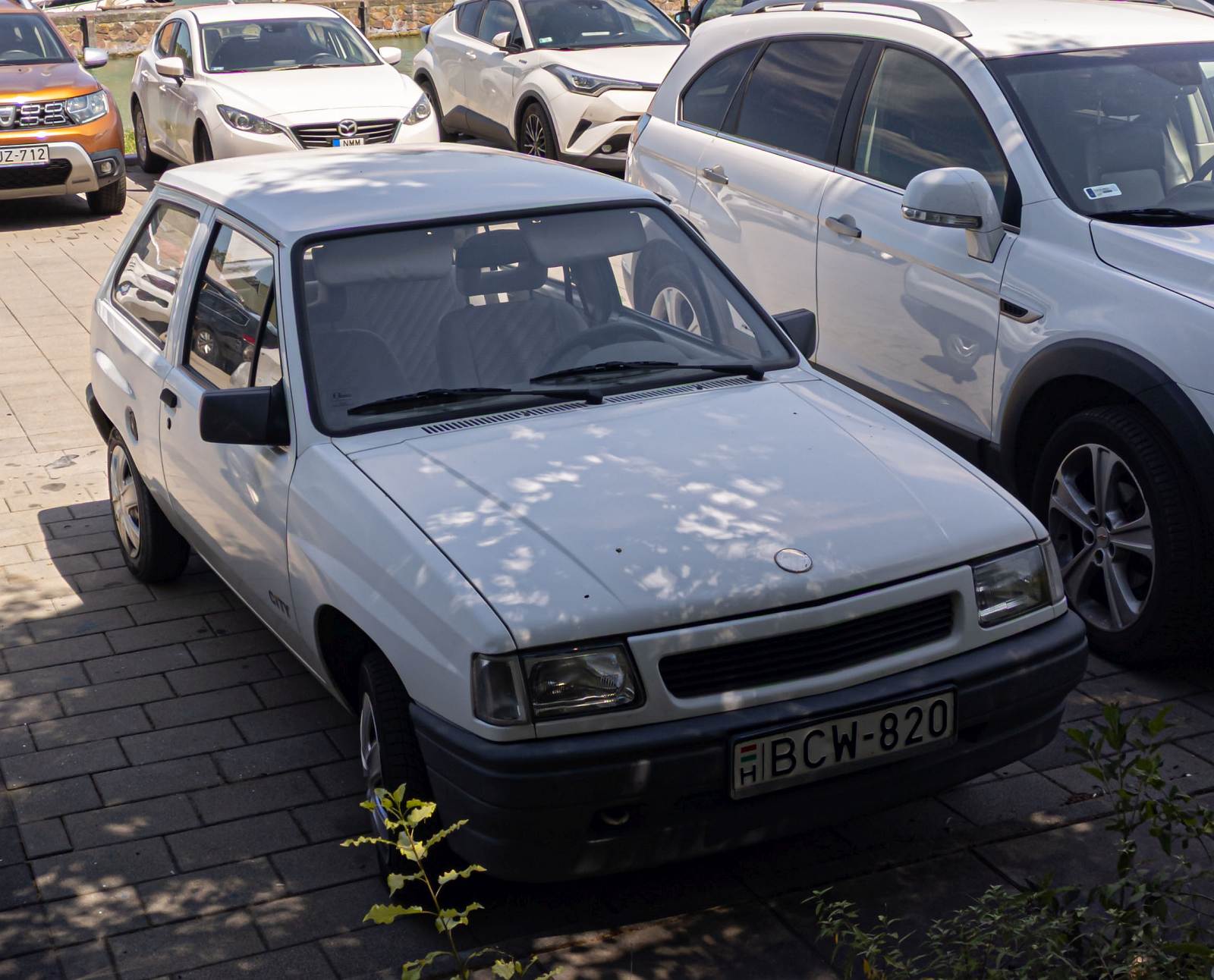 Opel Corsa A auf einem öffentlichen Parkplatz an einem Urlaubsort. Foto: Juli, 2023.