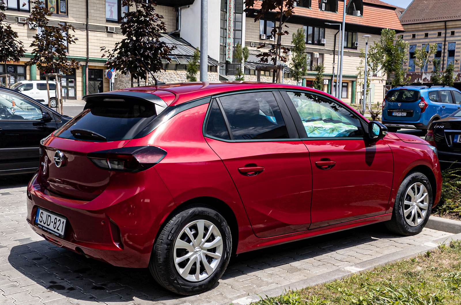 Rückansicht / Seitenansicht: Opel Corsa F in Kardiorot. Foto: Juli, 2022