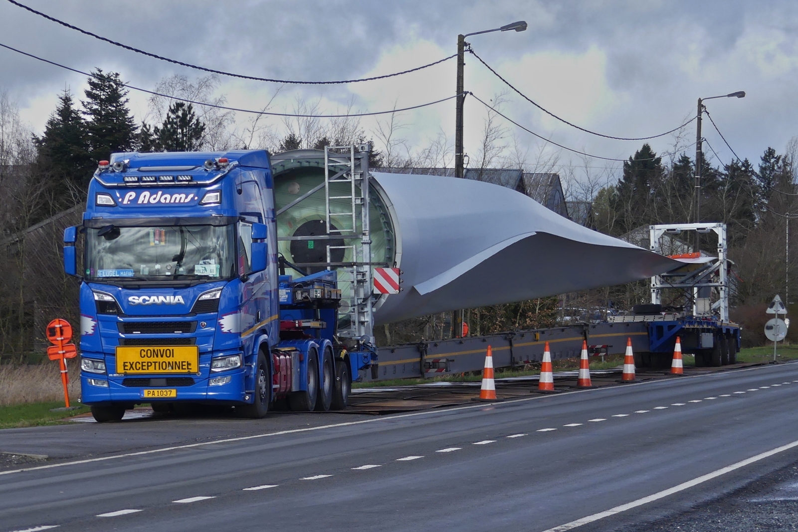 Scania R850 Schwerlastsattelzug, mit einem Windkraftflgel macht Rast, auf dem mit Blechtafeln ausgelegten Seitenstreifen nahe der luxemburgischen – belgischen Grenze bei Doncols. 28.03.2024