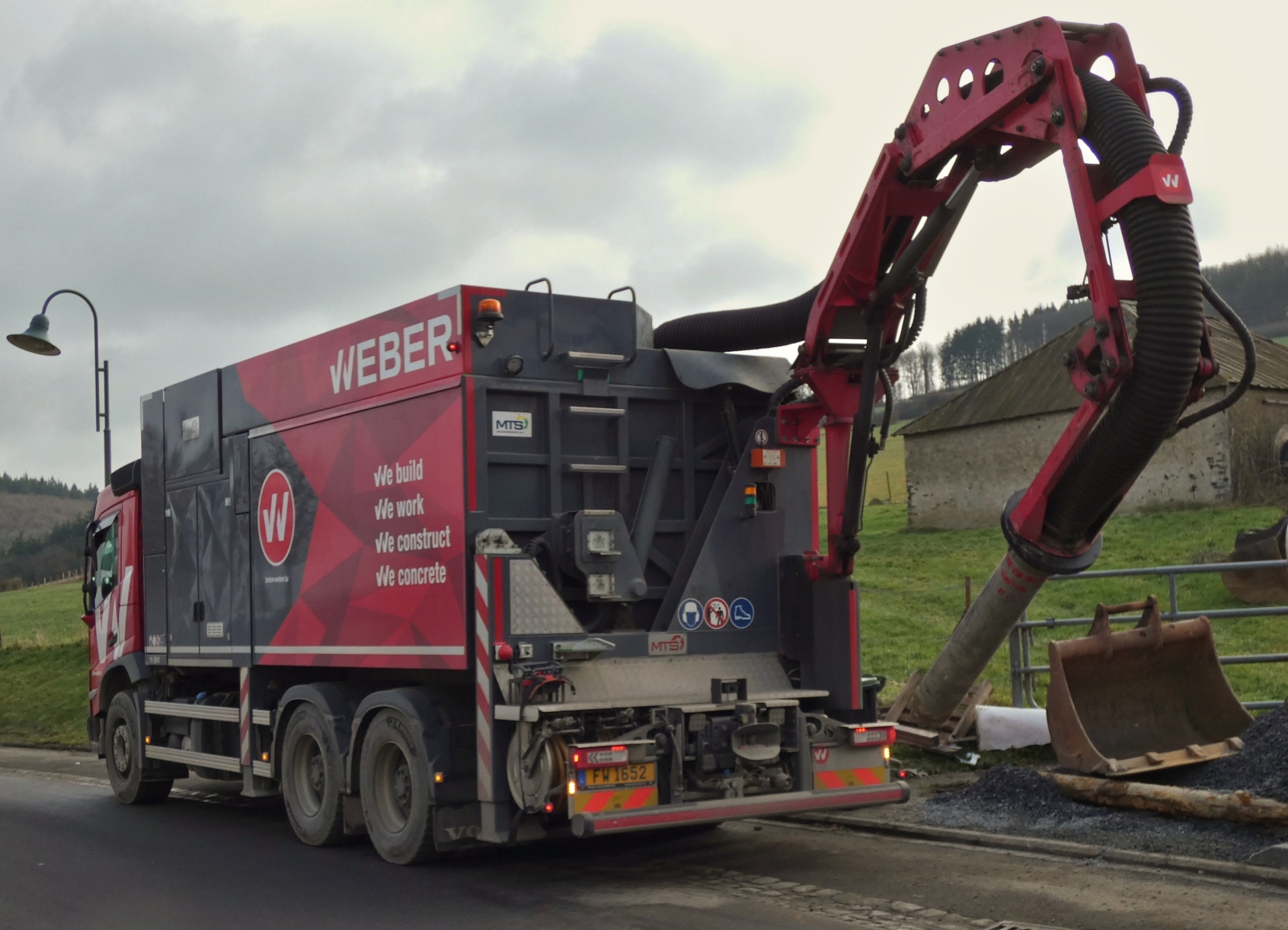 Volvo LKW mit Sonderaufbau zum Saugen und Bohren an schwer zugänglichen Stellen, beim ausfahren des Saugrohres an einer Baustelle. 01.2026