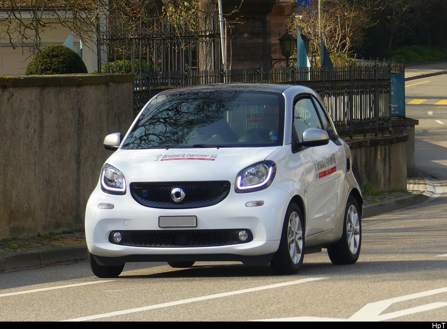 Weisser Smart mit Werbung unterwegs in Bottmingen am 22.03.2026