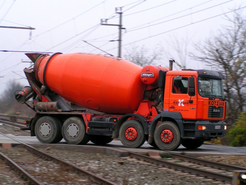 MAN 32.414 Betonmischwagen der Fa. Kotzian quert den Bahnbergang in Bruck/Leitha; 081112