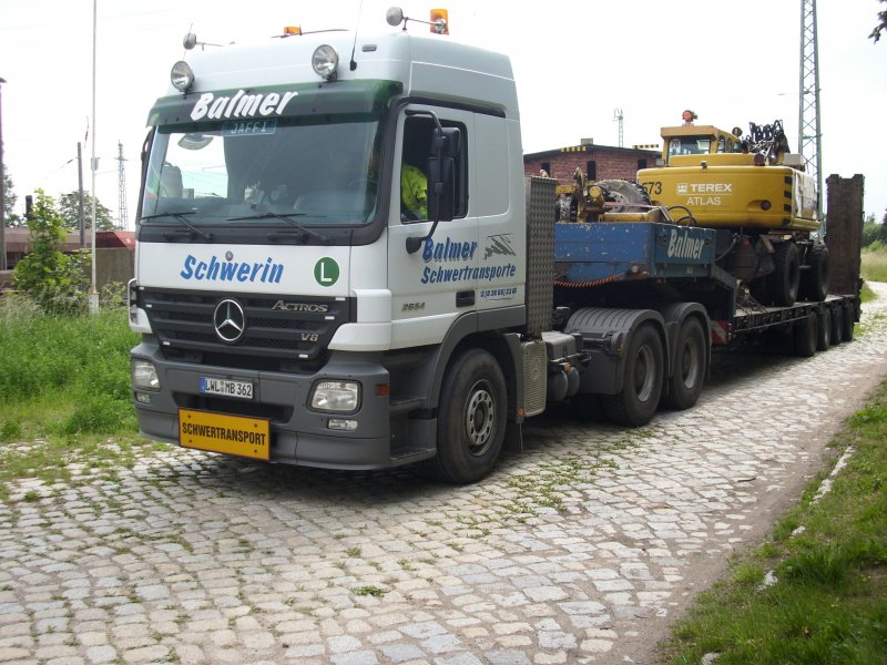 Mercedes-Schwerlasttransporter mit einem Zweiwegefahrzeug auf der Ladeflche am 11.Juni 2009 auf der Ladestrae in Bergen/Rgen.