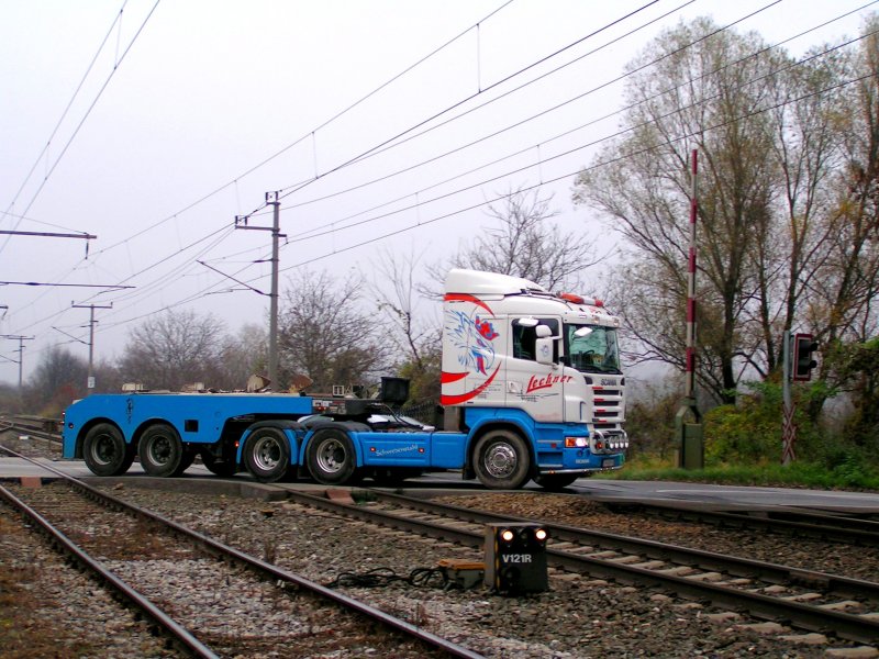 Scania mit Flachauflieger überquert den Bahnübergang bei KM39.7 bei Bruck/Leitha; 081112