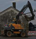 Volvo Radlader EW160C wartet mit gefüllter Schaufel auf einen Lkw um diese zu entleeren.