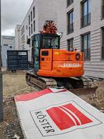 =Raupenbagger der Firma SCHLESER steht auf einer Baustelle in Fulda, 03-2026