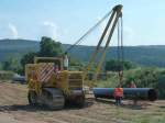 Komatsu D 355 C bringt das gebogene Stahlrohr zum Lagerplatz beim Gasleitungsbau an der MIDAL-Trasse in 36100 Petersberg-Marbach, August 2013