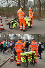 Zwei Rettungssanitäter der Johanniter mit ihren umfangreich ausgestatteten Fahrrädern anläßlich des alljährlichen Silvesterlaufs des SCC Berlin im Berliner Grunewald am