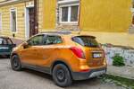 Rückansicht: Opel Mokka X in  Amber Orange . Aufnhame: April, 2021.