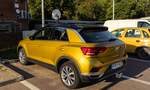 Rückansicht / Seitenansicht: VW T-Roc in der Farbe Kurkumagelb (Kurkuma Yellow). Die Aufnahme stammt von Juni, 2022.