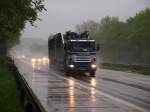Niederländischer Scania Hängerzug beladen mit Mist auf der A4 kurz vor der Grenze im Regen unterwegs.