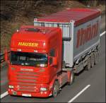 Scania R500 8/ von HAUSER ist mit einem Container mit der Aufschrift THNI bei Ldenscheid in Richtung Sden unterwegs.